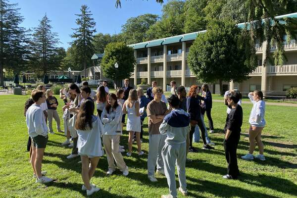 Sheedy Family Program students standing in a circle outdoors interacting at their fall retreat in 2023