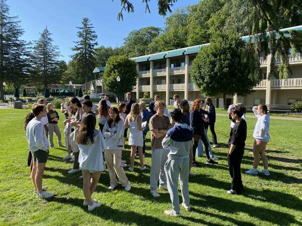 Sheedy Family Program students standing in a circle outdoors interacting at their fall retreat in 2023