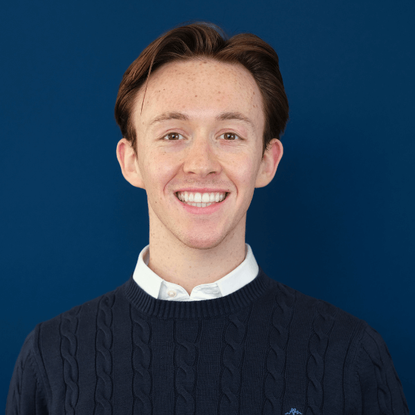Headshot of Sheedy student Ryan Bland, with a blue background behind him
